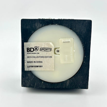 Underside of bobblehead to show copyright info and battery compartment on a light gray background
