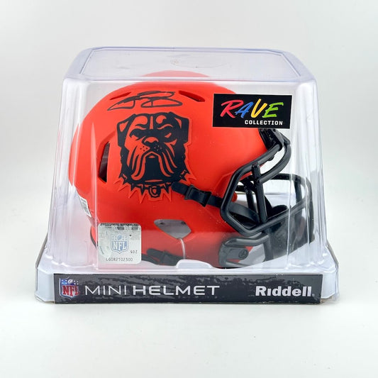 Orange mini football helmet with black logo in clear packaging on a white background