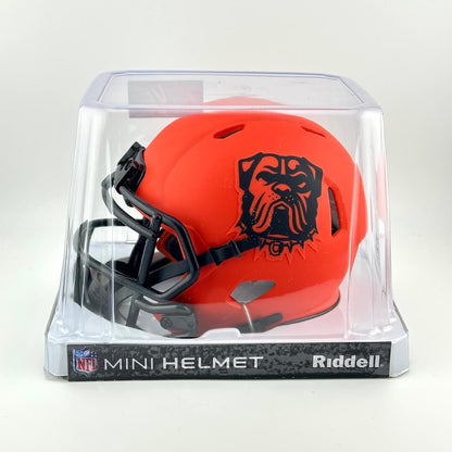 Orange mini football helmet with black logo in clear packaging, featuring Riddell branding.