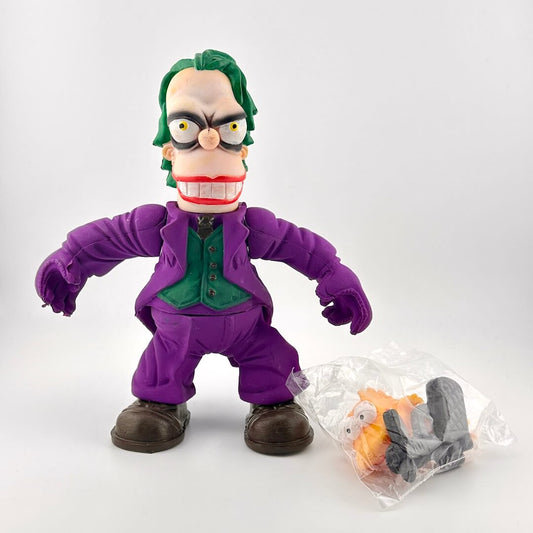 Toy figure of a character in a purple suit with a small package of accessories on a white background