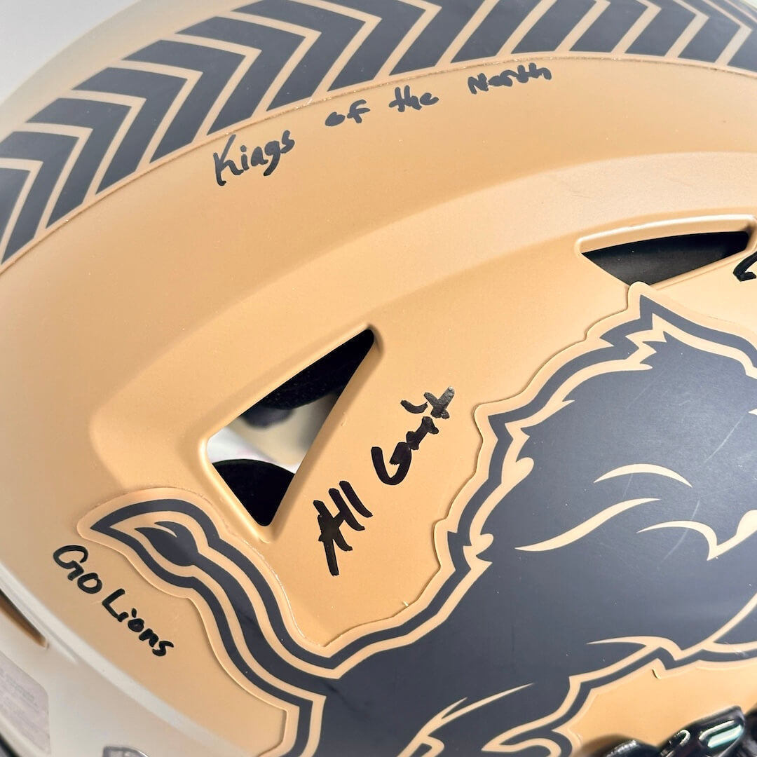 Close-up of a football helmet with 'Kings of the North,' 'All Grit' and 'Go Lions' text, featuring a lion logo.