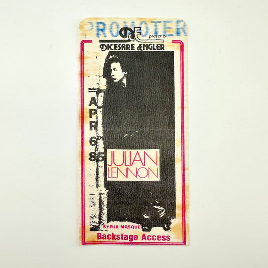 Backstage pass with black and white image of artist and event details in black text. 