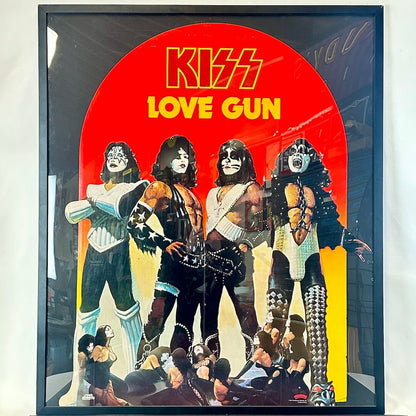 Framed cutout of KISS band members from the album 'Love Gun' with a red and yellow background.