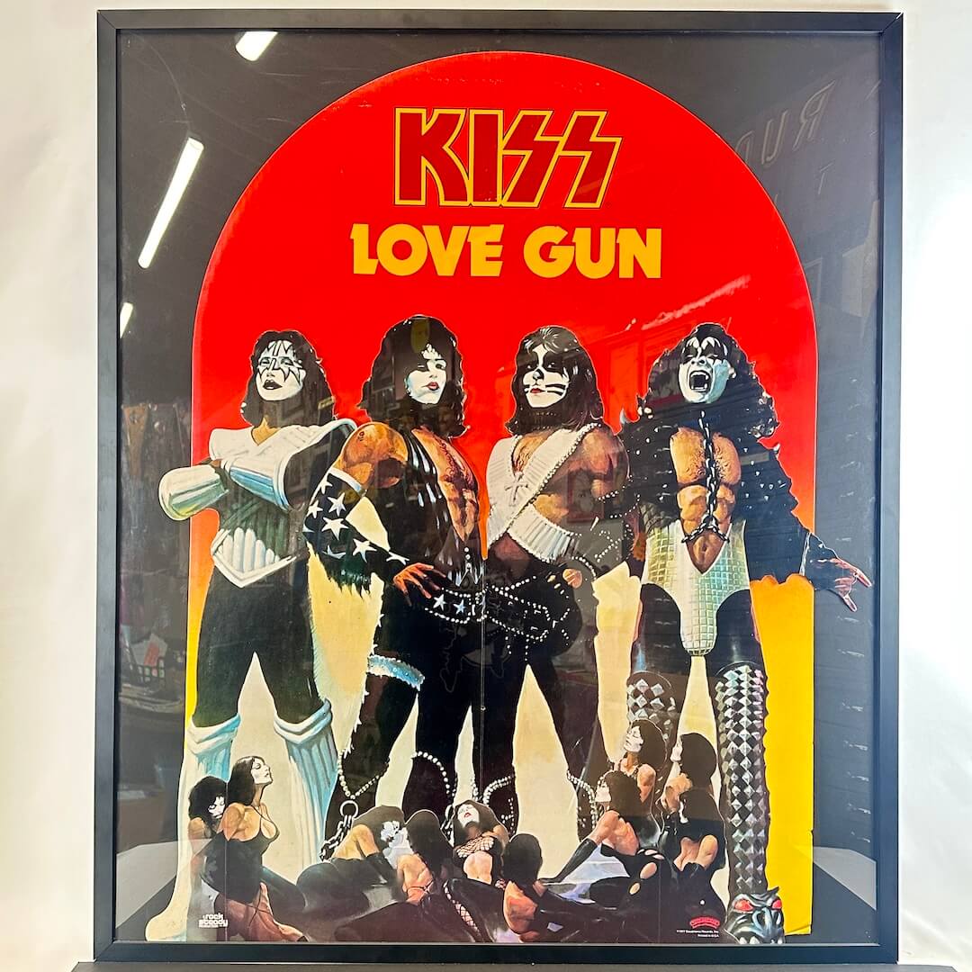Framed cutout of KISS album 'Love Gun' with band members and red background.