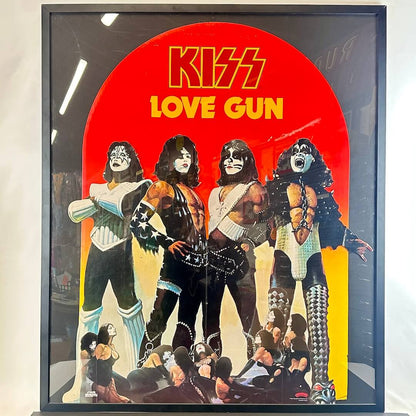 Framed cutout of KISS album 'Love Gun' with band members and red background.