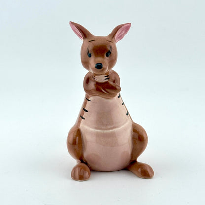 A ceramic kangaroo figurine in shades of brown and pink, sitting against a plain light gray background.