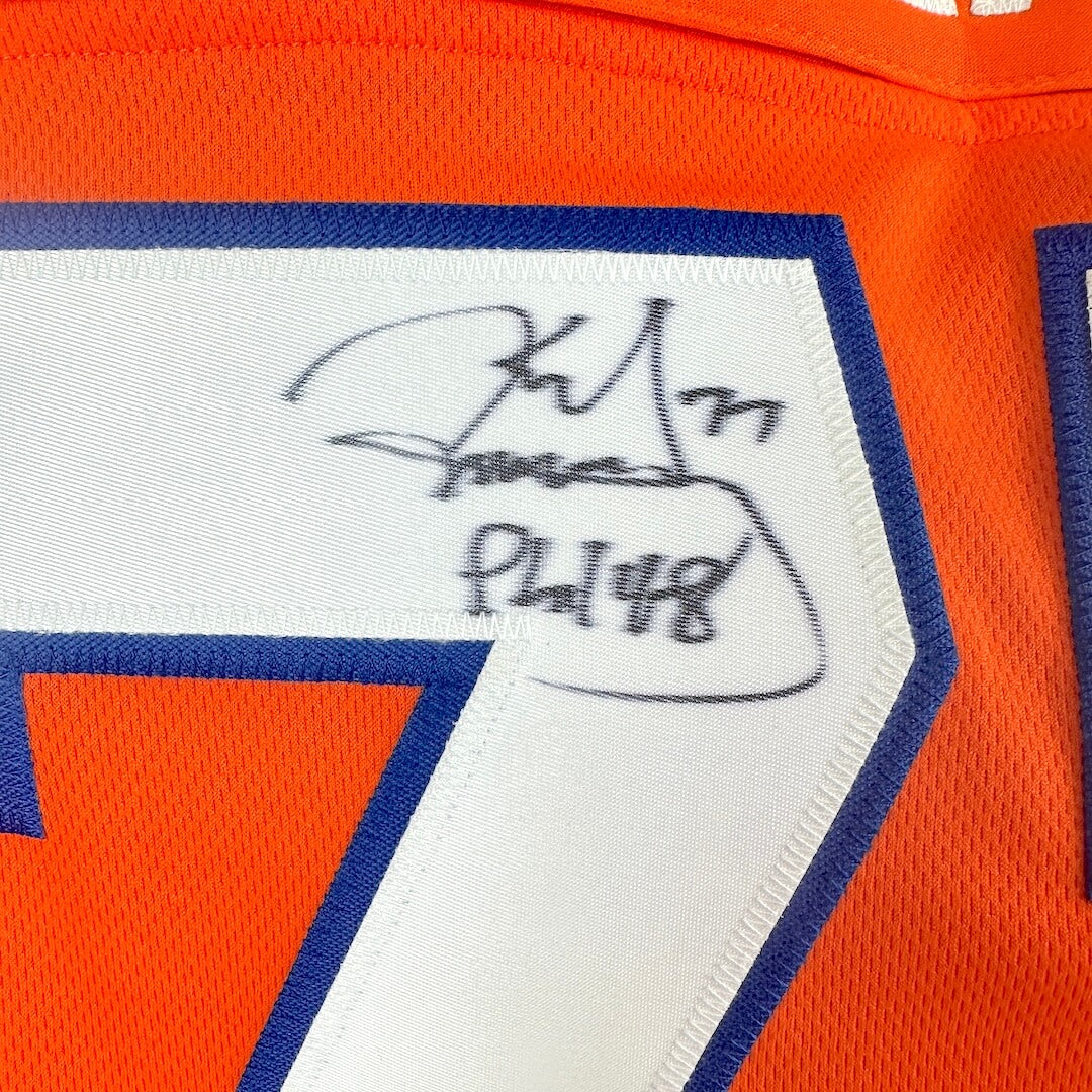 Close-up of a sports jersey with a signature and number on an orange background