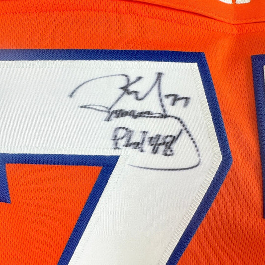 Close-up of a sports jersey with a signature and number on an orange background