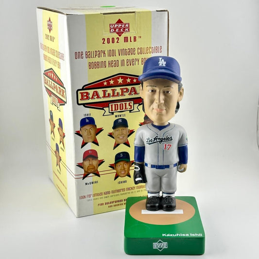 Bobblehead figure of a baseball player in front of its packaging box on a white background