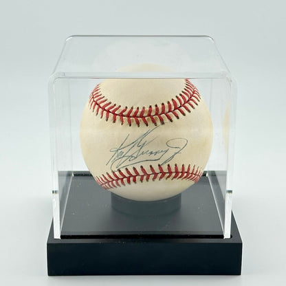 Autographed baseball in plastic cube with black base. 