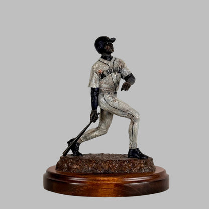 Side view of Ken Griffey Jr. bronze statue of him posed at the end of a swing, his signature etched into wooden base.
