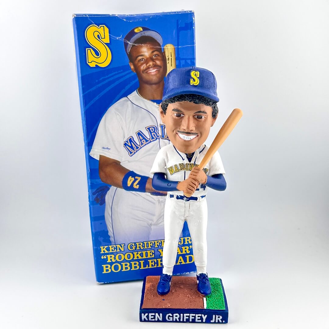 Bobblehead of a baseball player holding a bat with packaging in the background