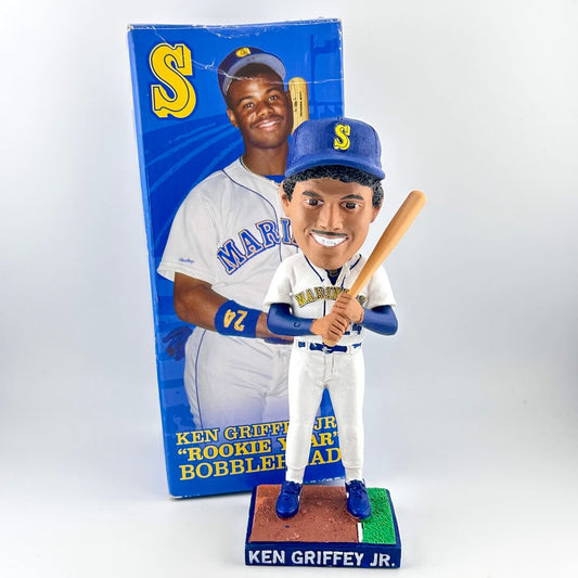 Bobblehead of a baseball player holding a bat with packaging in the background