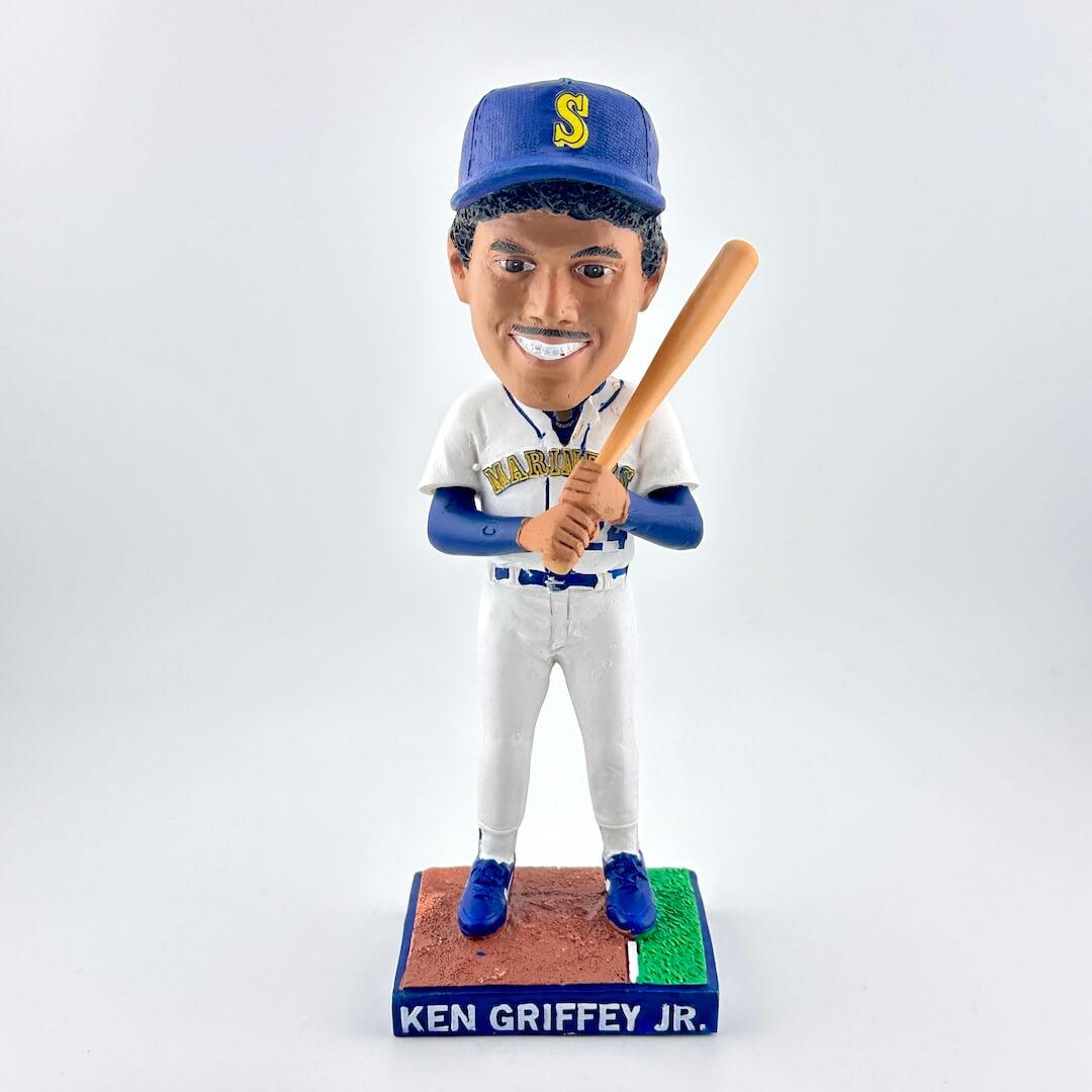 Bobblehead of a baseball player in a Mariners uniform holding a bat on a white background