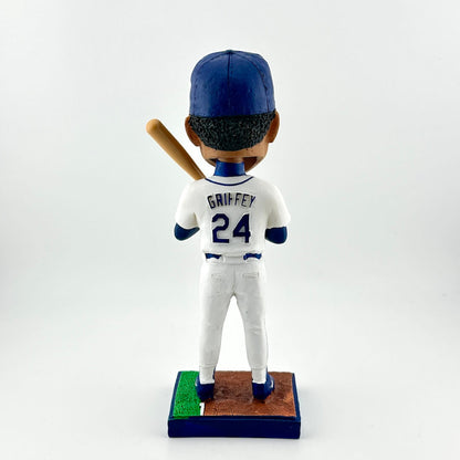 Bobblehead figure of a baseball player in a white uniform with blue accents, holding a bat on a white background.