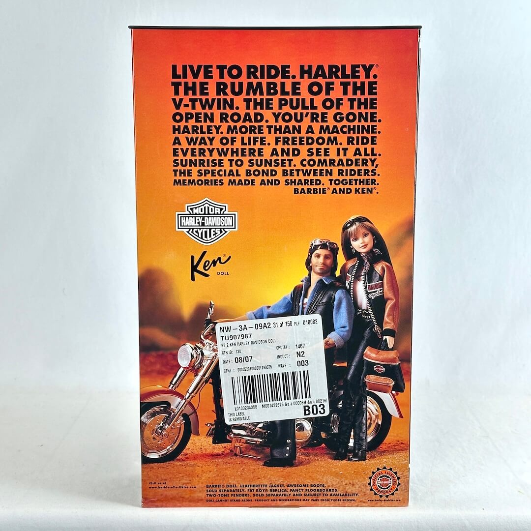 Ken Harley-Davidson doll box showing the back with illustration of Barbie and Ken on a motorcycle against an orange sunset background.