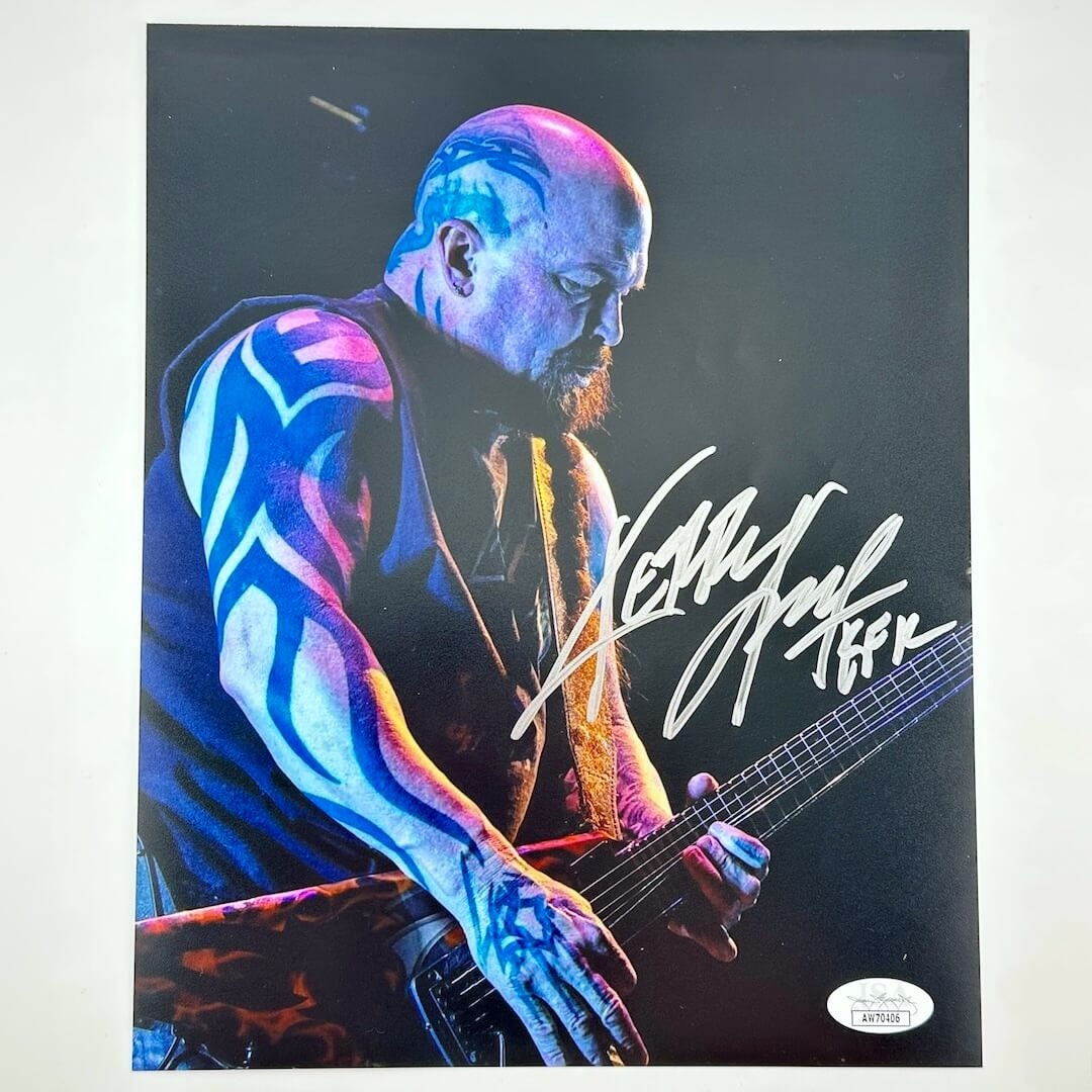 Man with tattoos playing guitar, signed on a black background