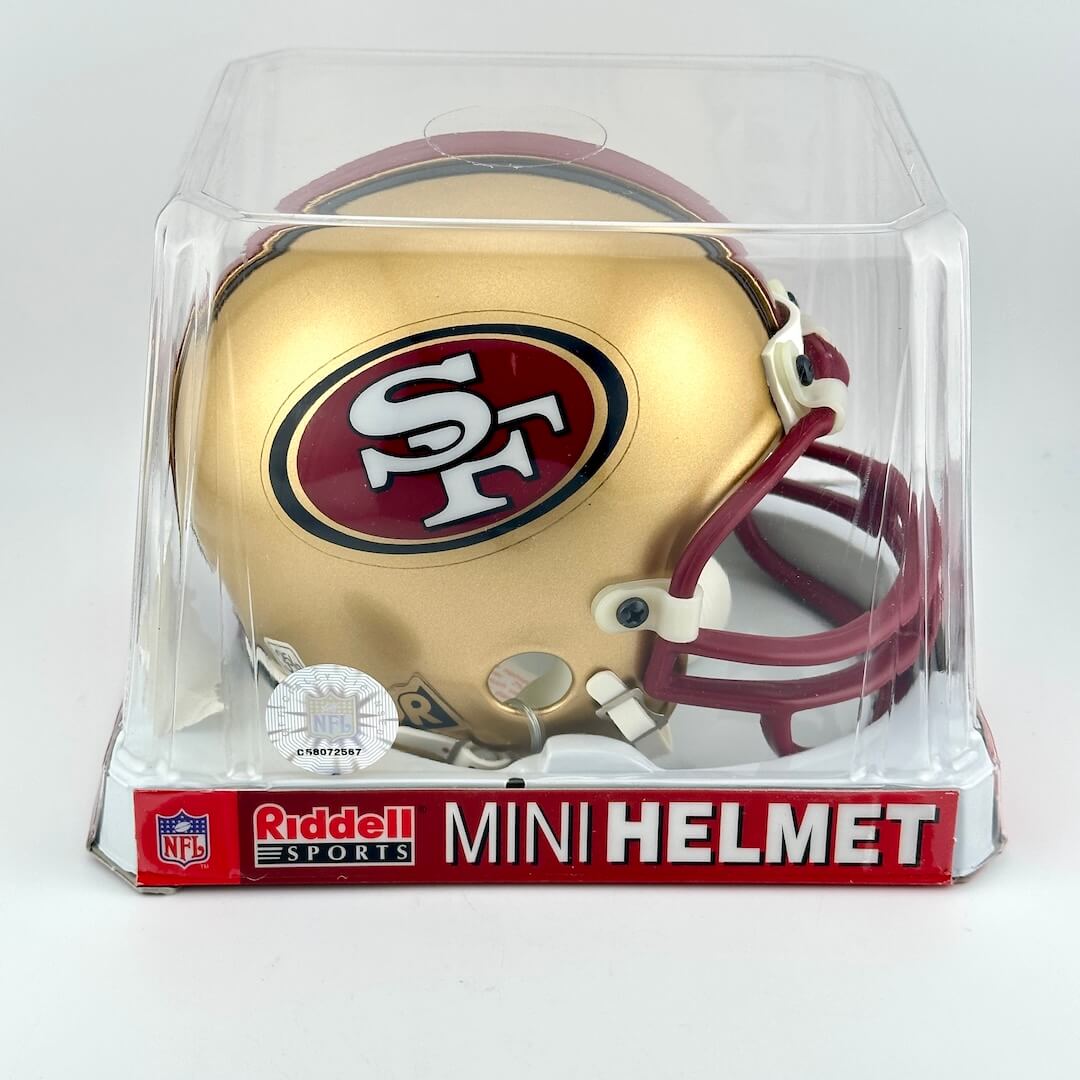 San Francisco 49ers mini helmet in clear packaging with Riddell Sports branding.