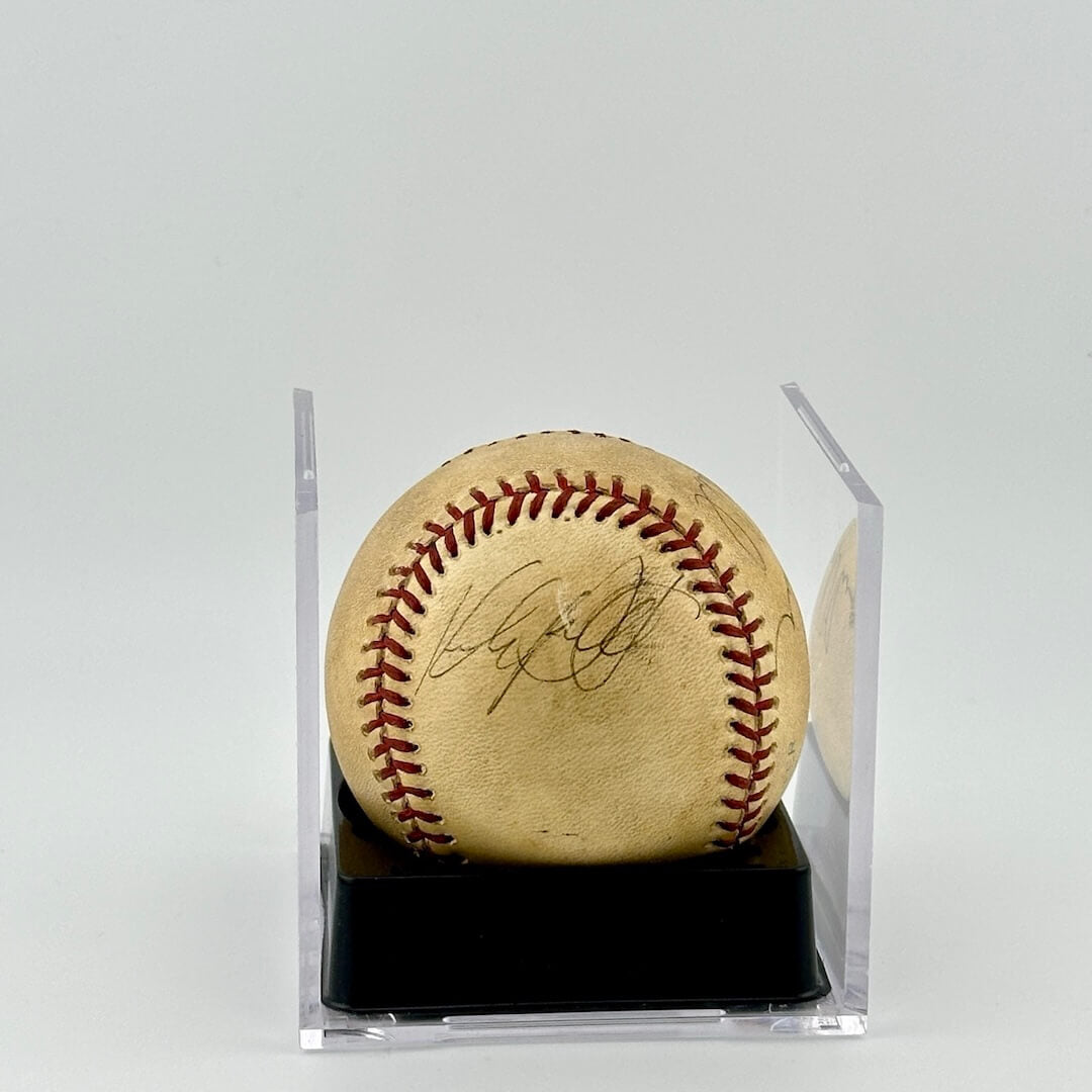 Autographed baseball in plastic cube with half of cube removed to show clear signature.