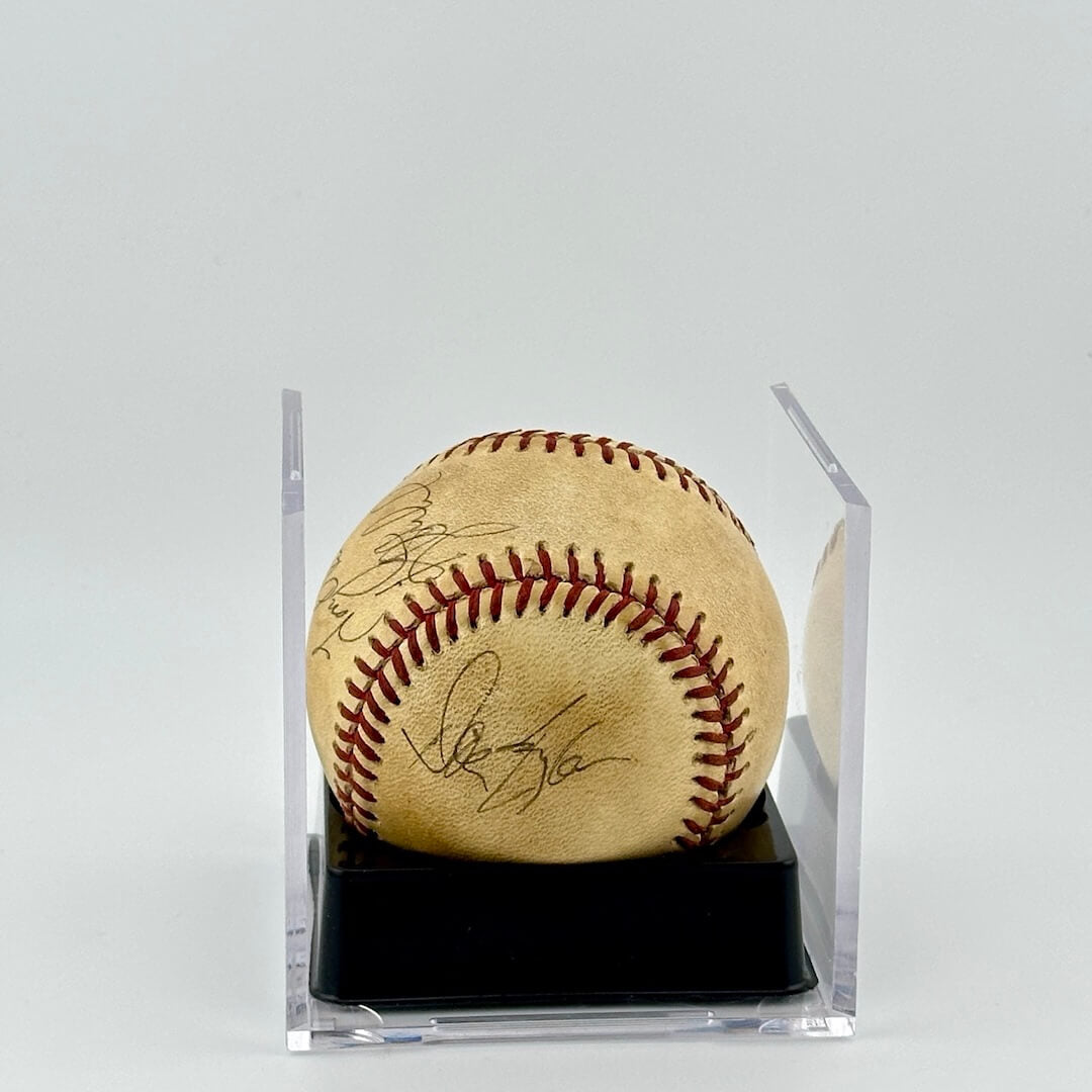 Autographed baseball in plastic cube with half of cube removed to show clear signatures.