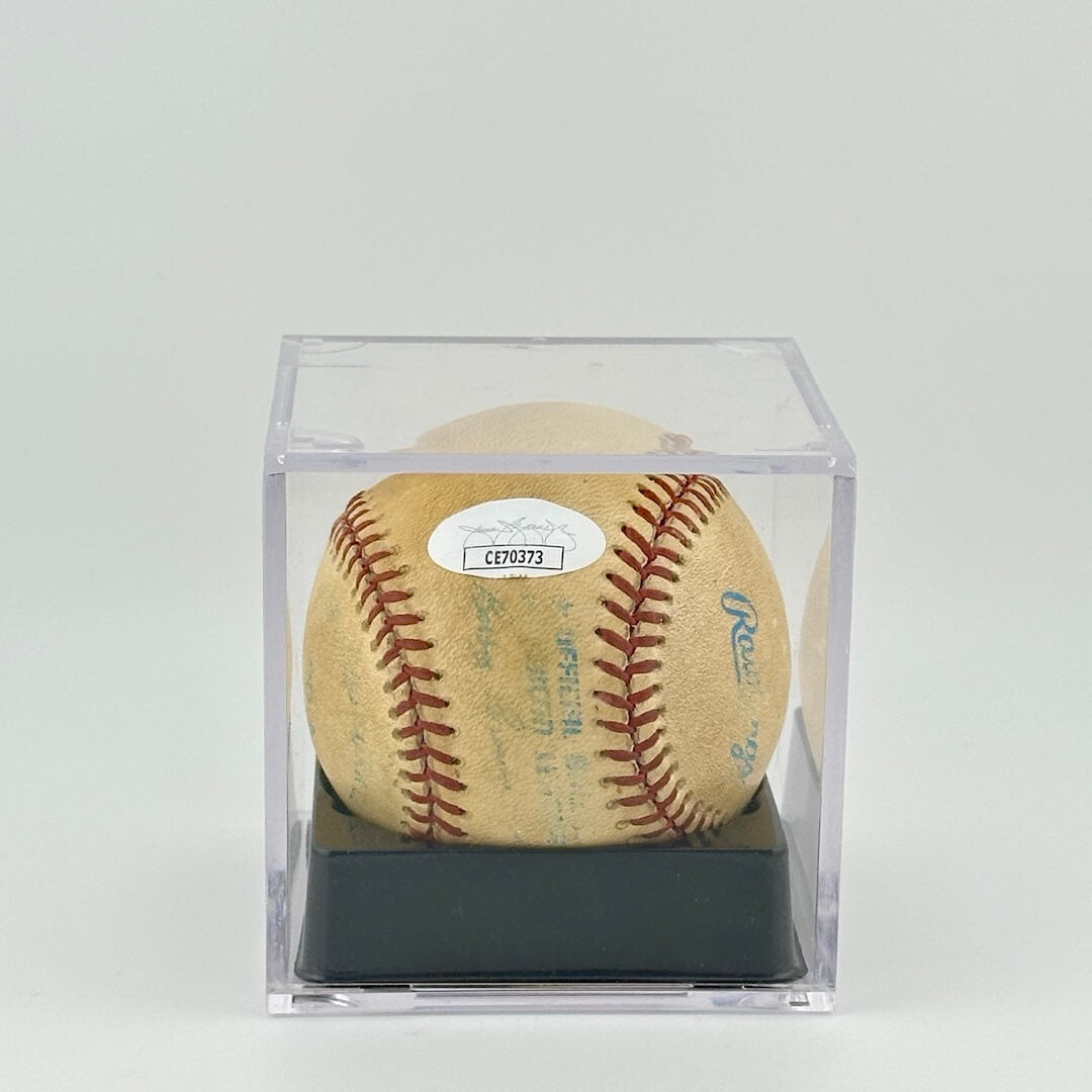 Autographed baseball in plastic cube with blue ball stamps and black pen signatures. JSA sticker on ball.
