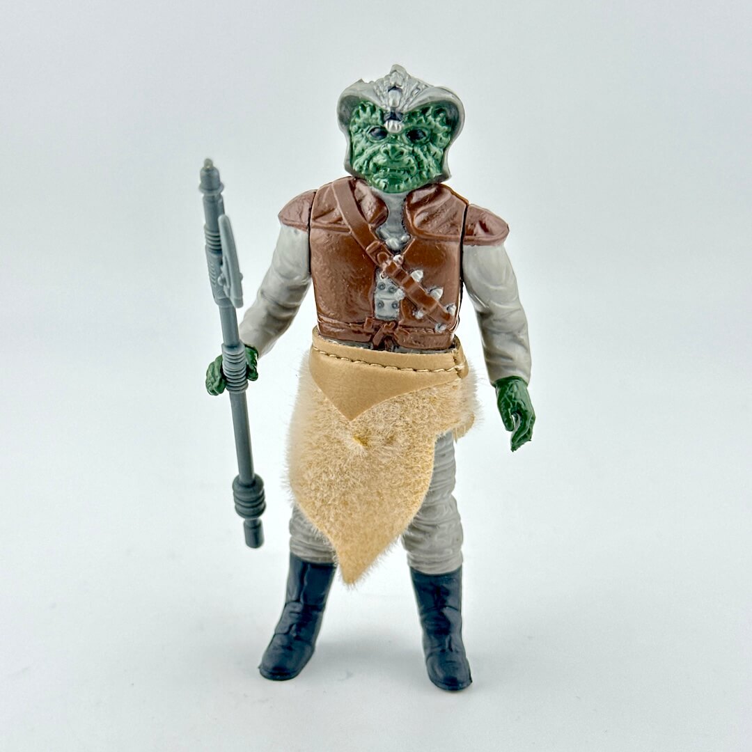 Alien action figure with accessory on white background. 