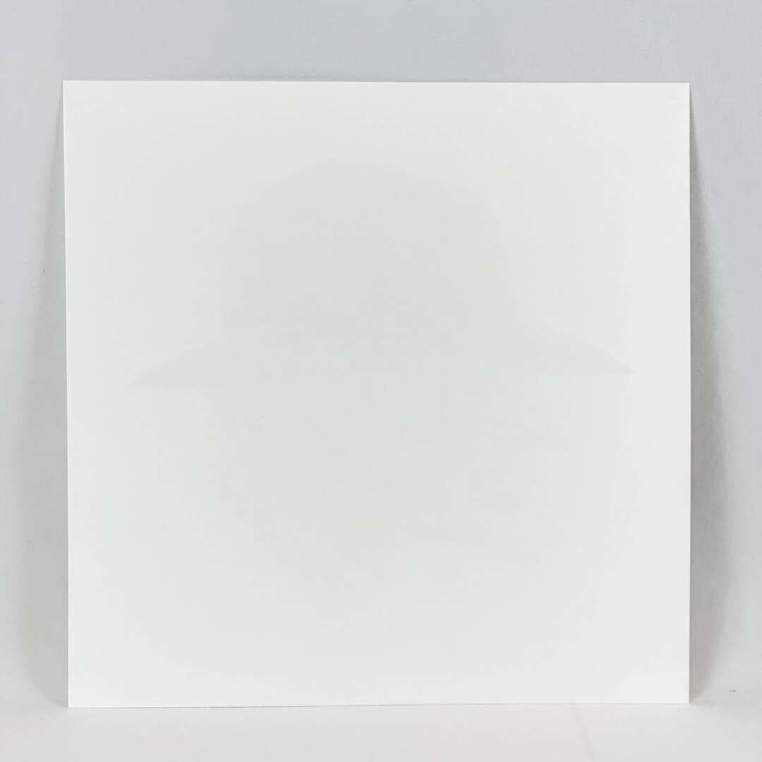 Reverse side of print showing no damage to face or edges. A plain, white square paper on a white background. 
