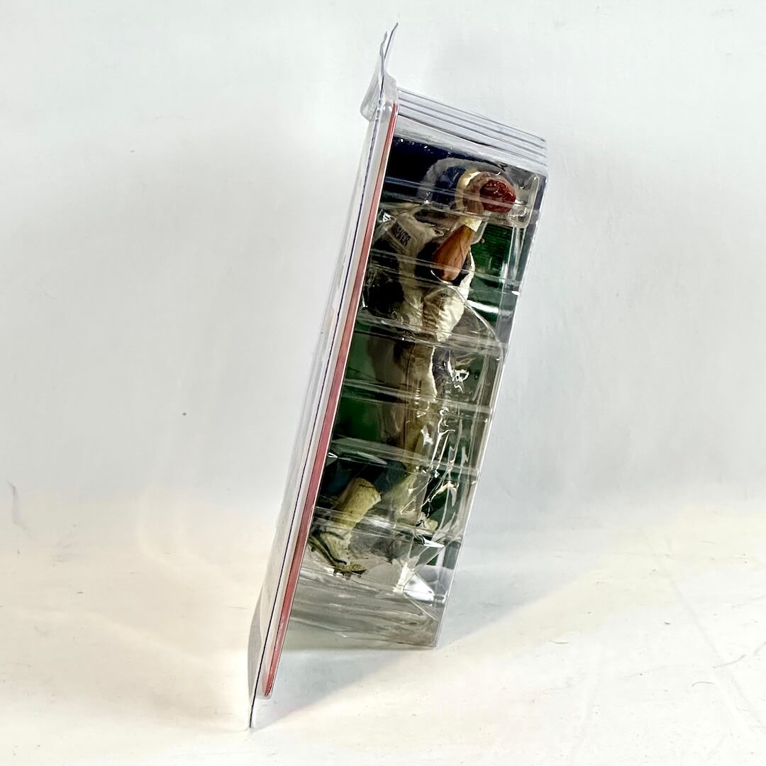 Clear plastic packaging with a small figurine inside on a white background