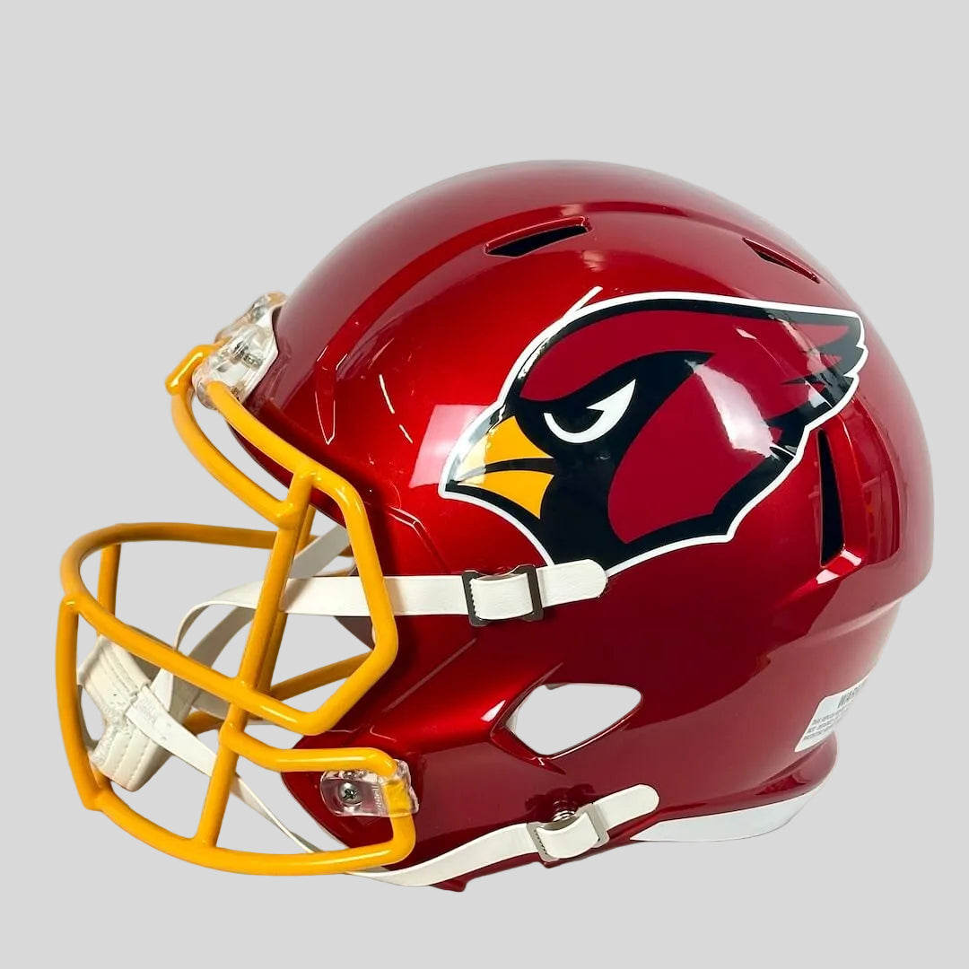 Side view of red football helmet with "Cardinals" logo on white background. 