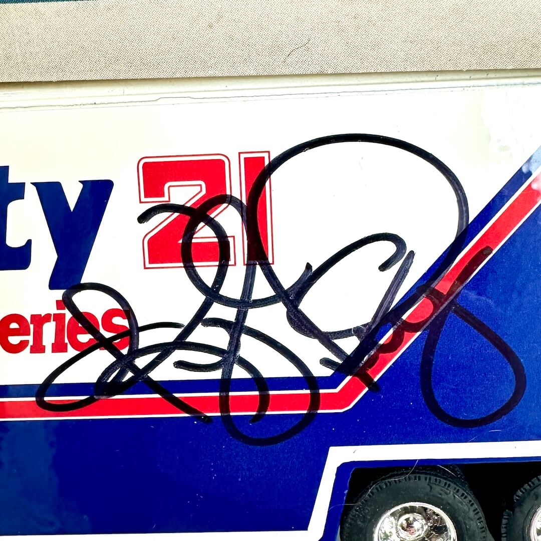 Close-up of a signature on a racing car decal with visible branding.