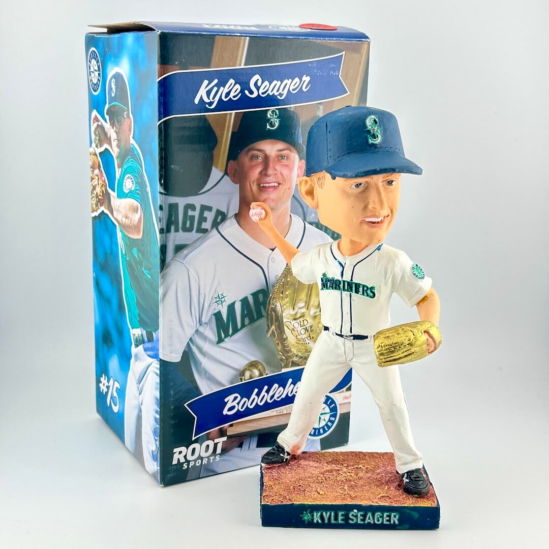 Bobblehead of baseball player in white uniform in pitching position with packaging on white background. 