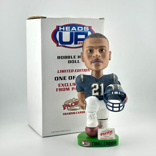 Football player bobblehead holding helmet with box against white background.