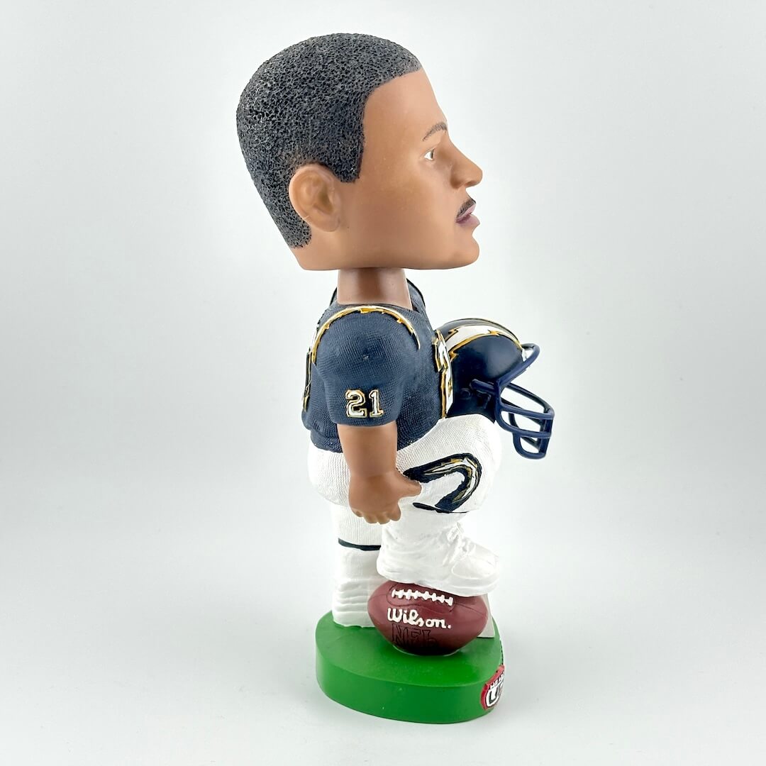 Bobblehead of a football player holding a helmet on a white background