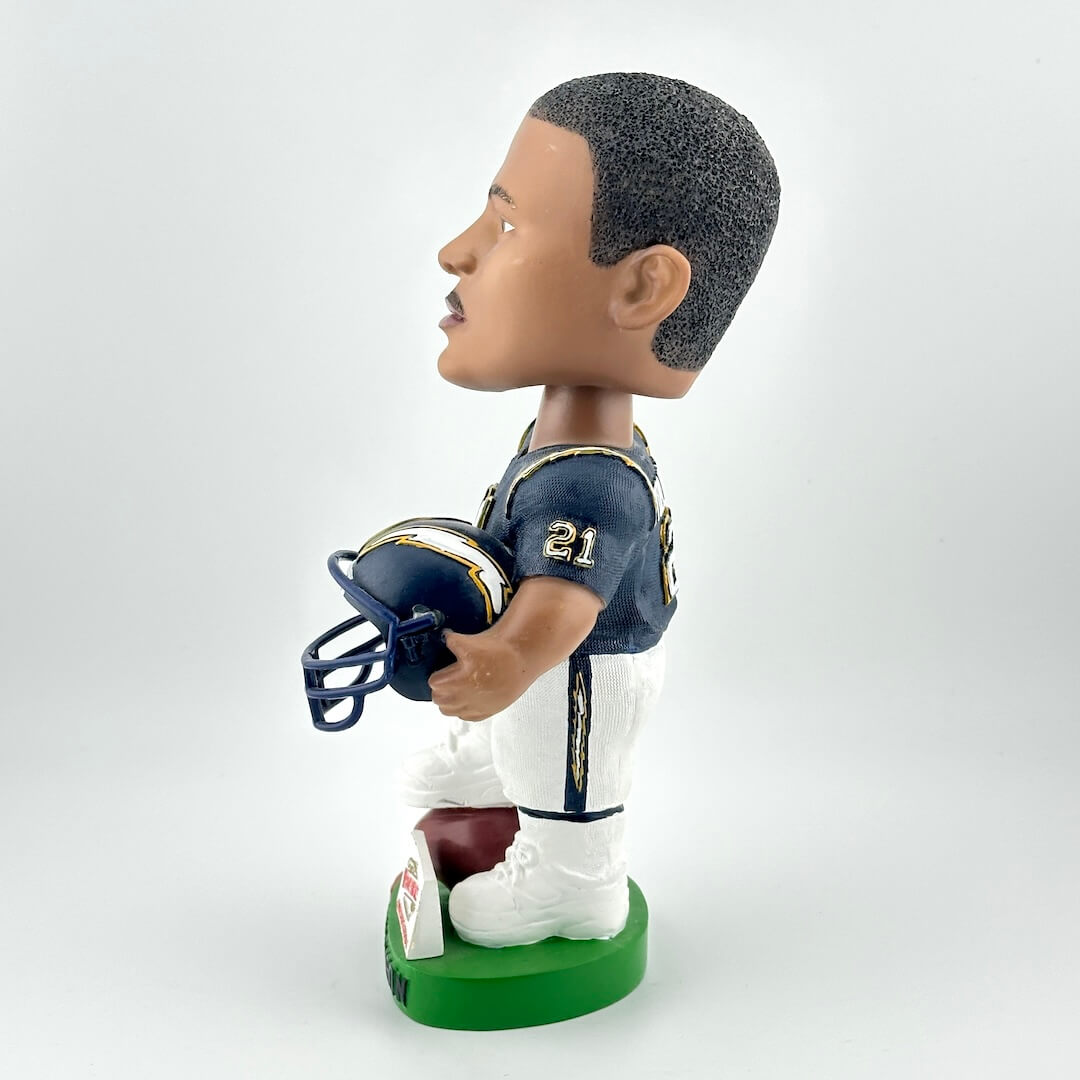 Bobblehead figure of a football player holding a helmet on a white background