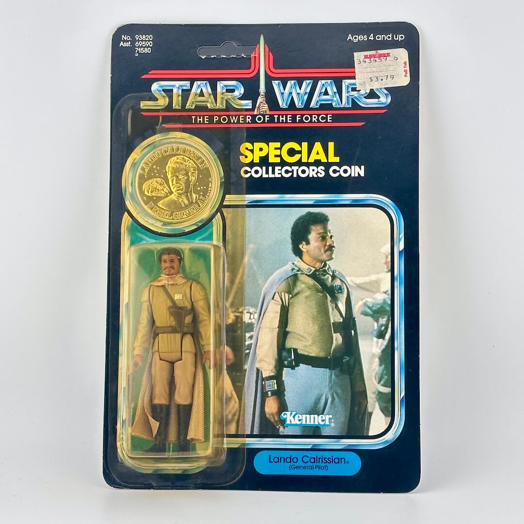 Star Wars action figure and coin packaging with Lando Calrissian on a white background