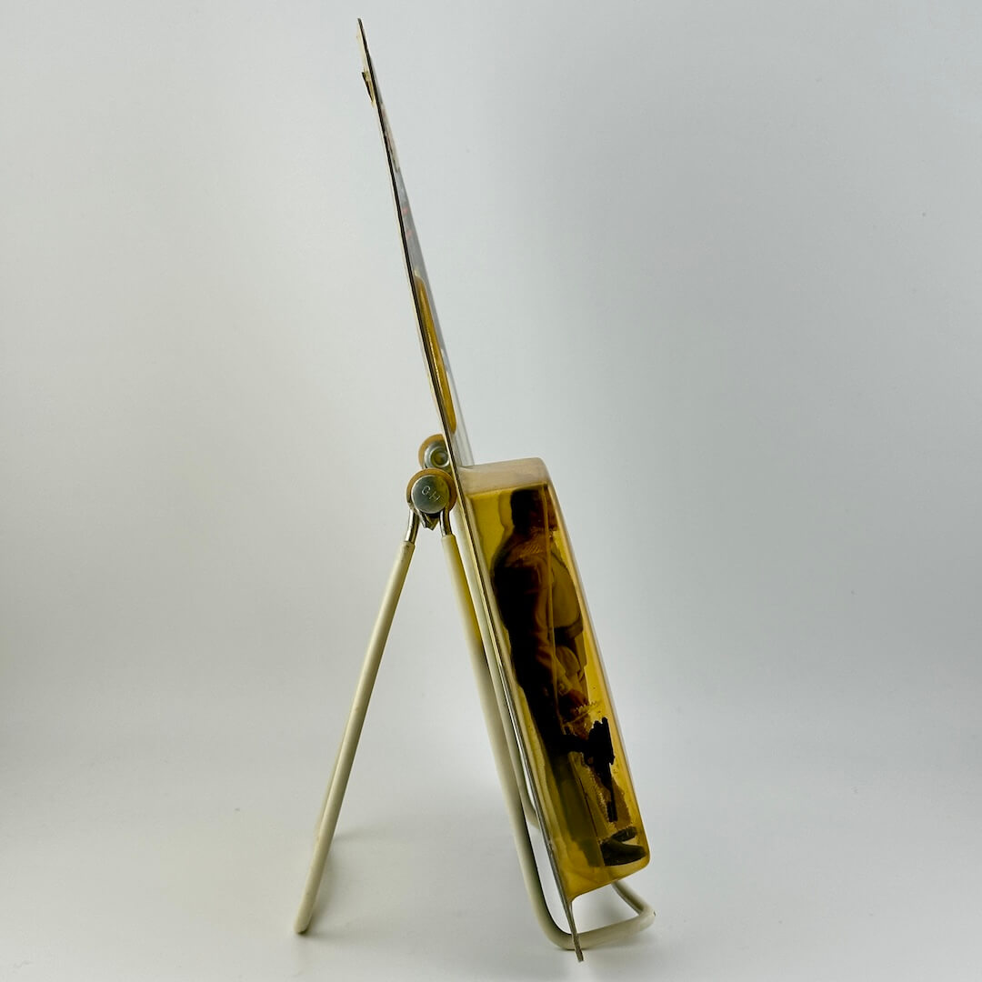 Side view of Star Wars action figure still in packaging on easel against white background.