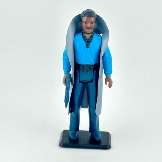 Action figure in blue outfit with cape and gun on a white background