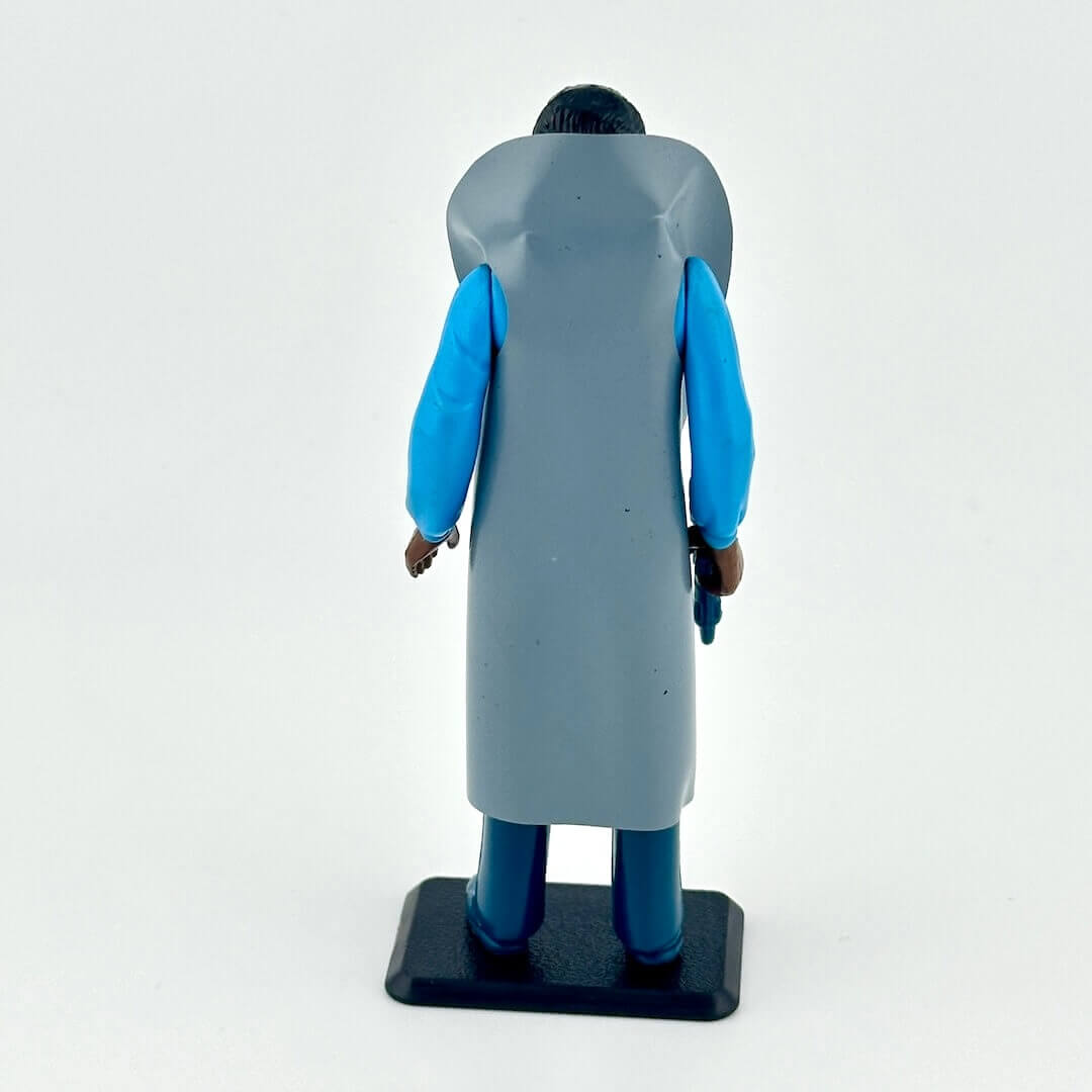 Figurine of a character wearing a gray coat with blue sleeves on a white background