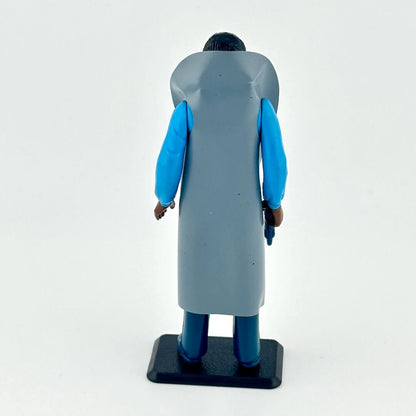 Figurine of a character wearing a gray coat with blue sleeves on a white background