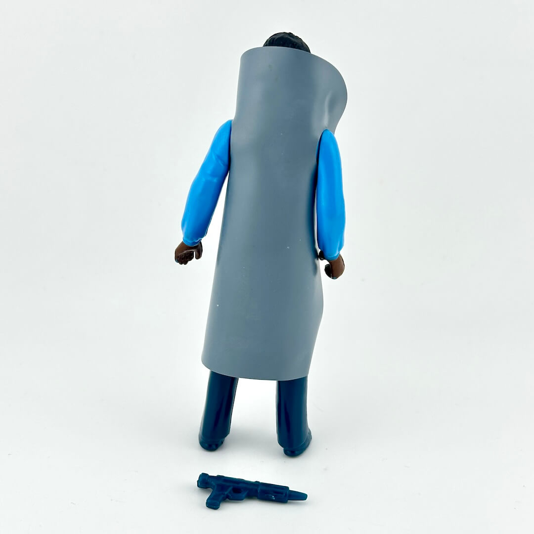 A toy action figure shown from the back, wearing a long gray coat over bright blue sleeves and dark blue pants.