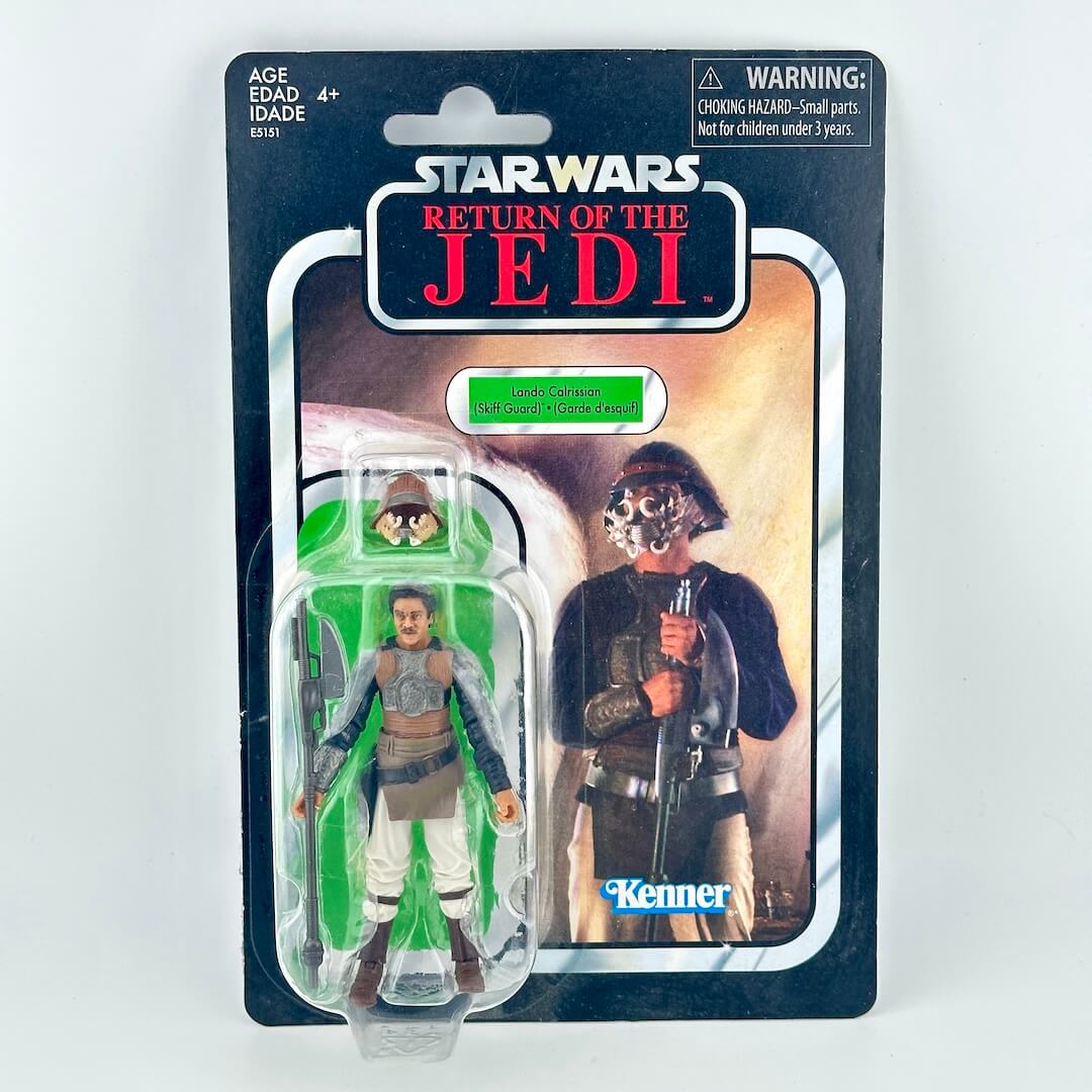 Star Wars action figure in its original blister packaging with retro-style card back, featuring figure in brown outfit. 