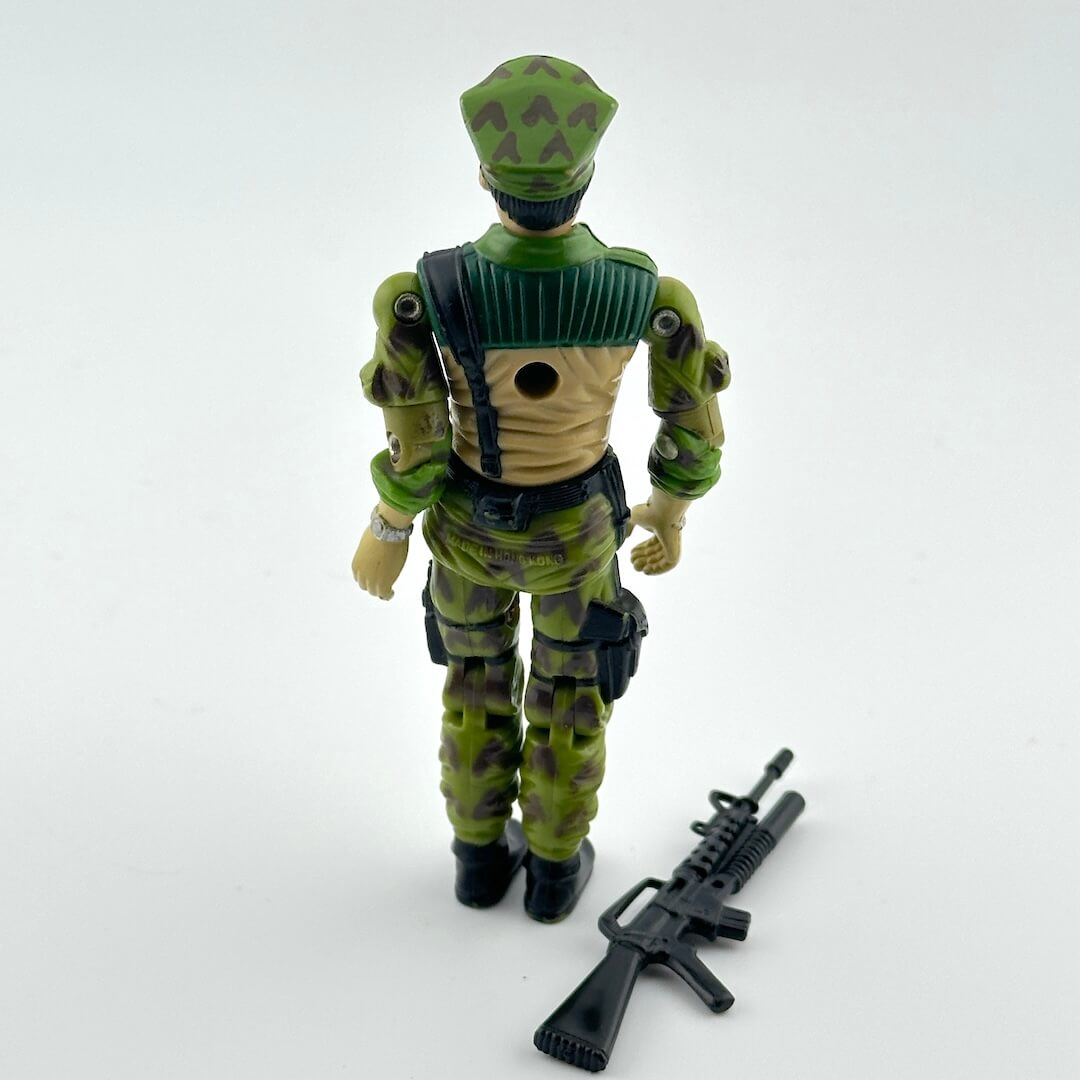 Toy figure in green camouflage uniform with a rifle on a white background