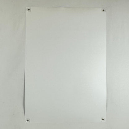 Backside of poster with no visible damage being held by magnets in each corner to a light surface. 