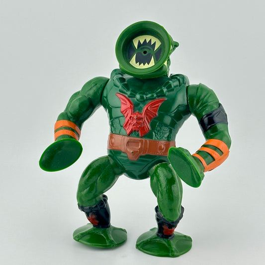 Green figure with suction cup face, hands & feet, red winged skull on chest, with orange gauntlets. 
