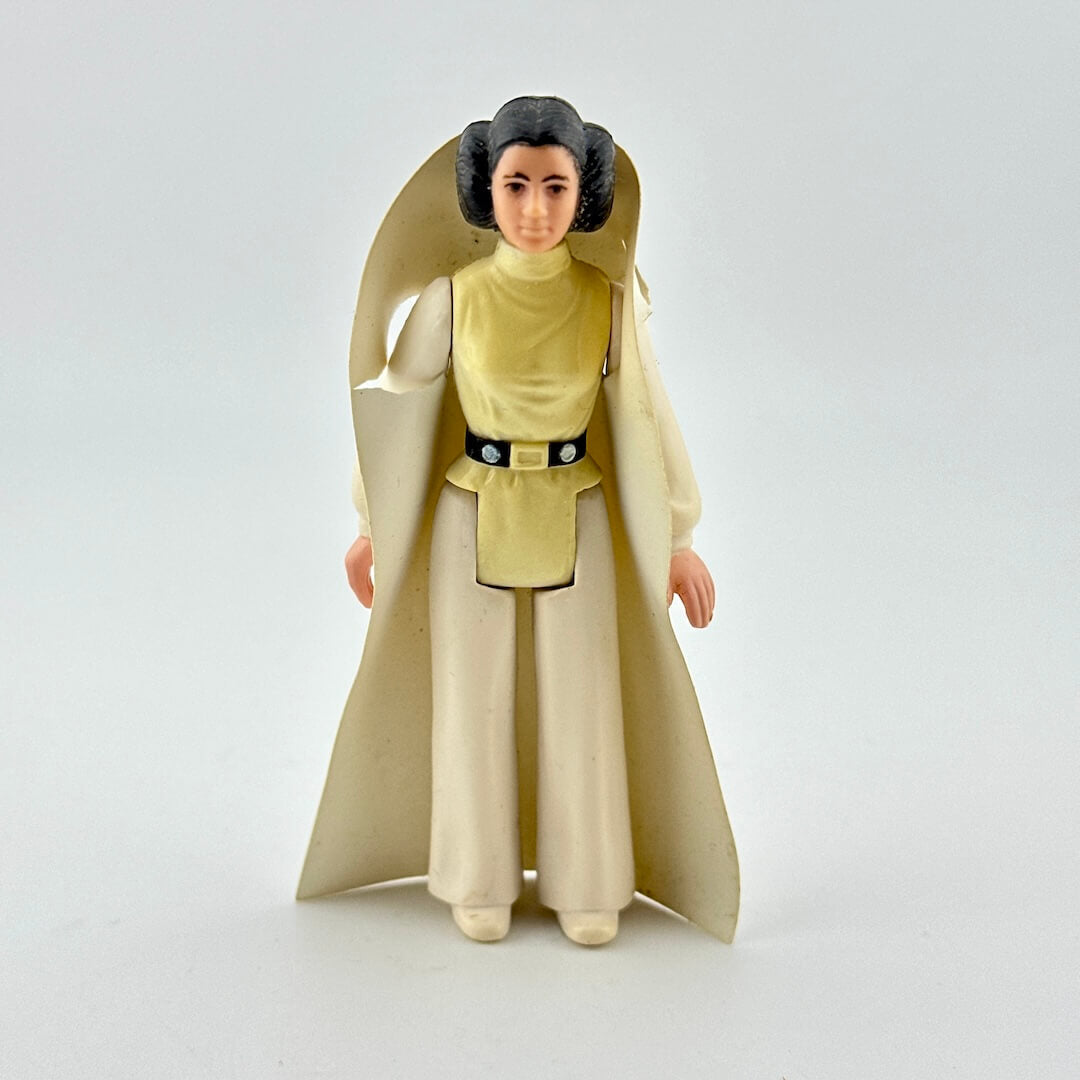 Toy figure of a character in a long beige robe on a white background