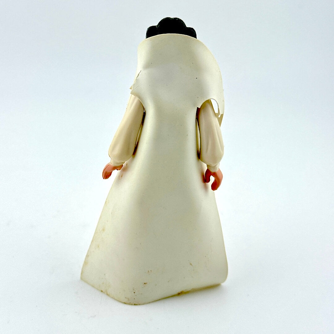 Toy figure of a character in a long white robe on a white background