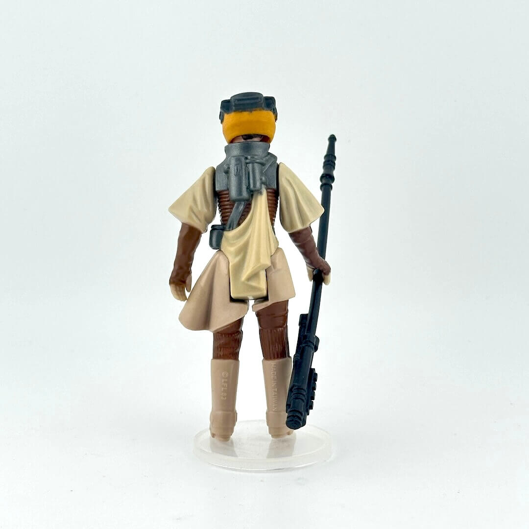 Leia action figure in tan outfit with a weapon on a white background