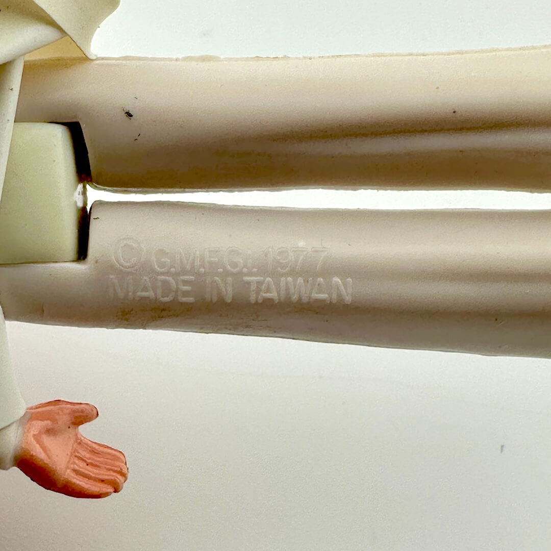 Close-up of a white plastic object with 'Made in Taiwan' text on a white background