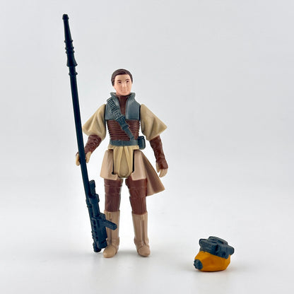 Action figure in a beige and brown outfit with a weapon on a white background