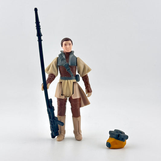Action figure in a beige and brown outfit with a weapon on a white background